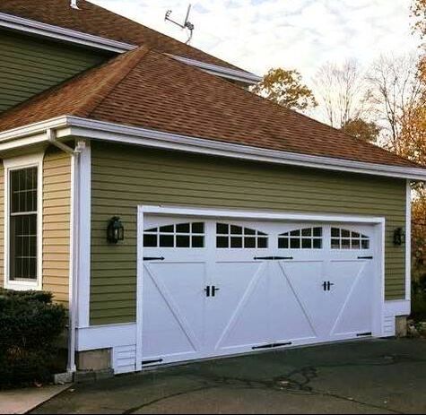 Clopay Carriage house double garage door in white with a V-brace overlay and arched windows