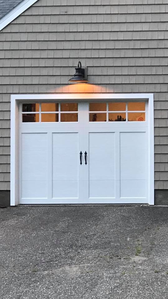 Clopay Coachman carriage house style garage door with windows and black handles installed in Southbury, CT by Absolute Garage Doors